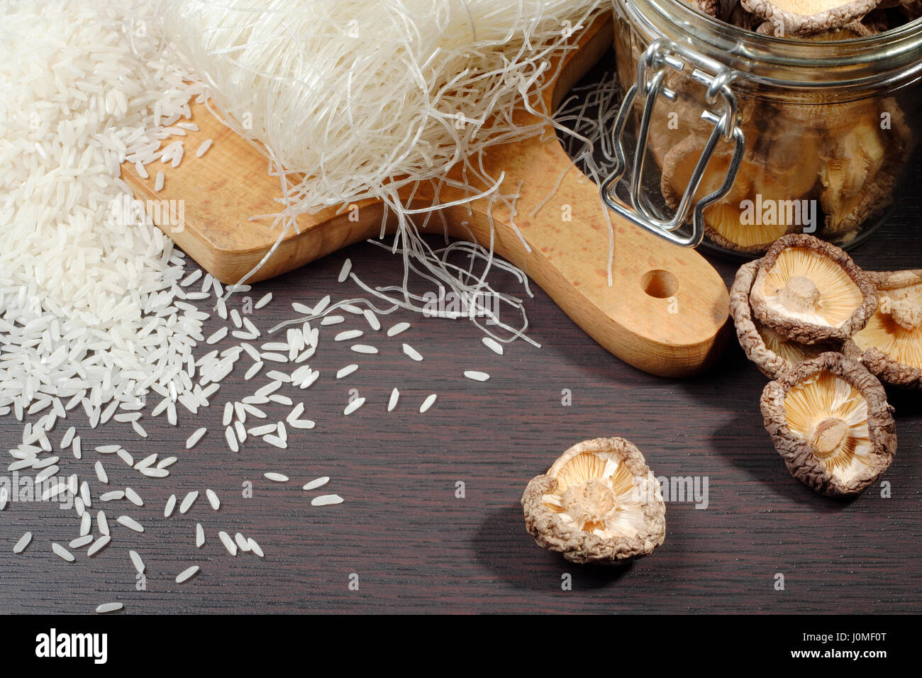 Still life with shiitake mushrooms (Poku) (Lentinus edodes), rice nodles and rice grain. Stock Photo
