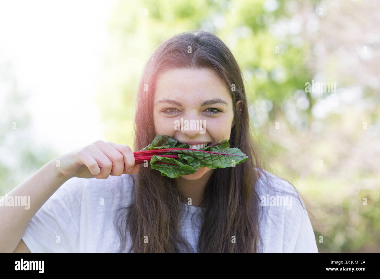 Young woman eating leaf vegetable Stock Photo