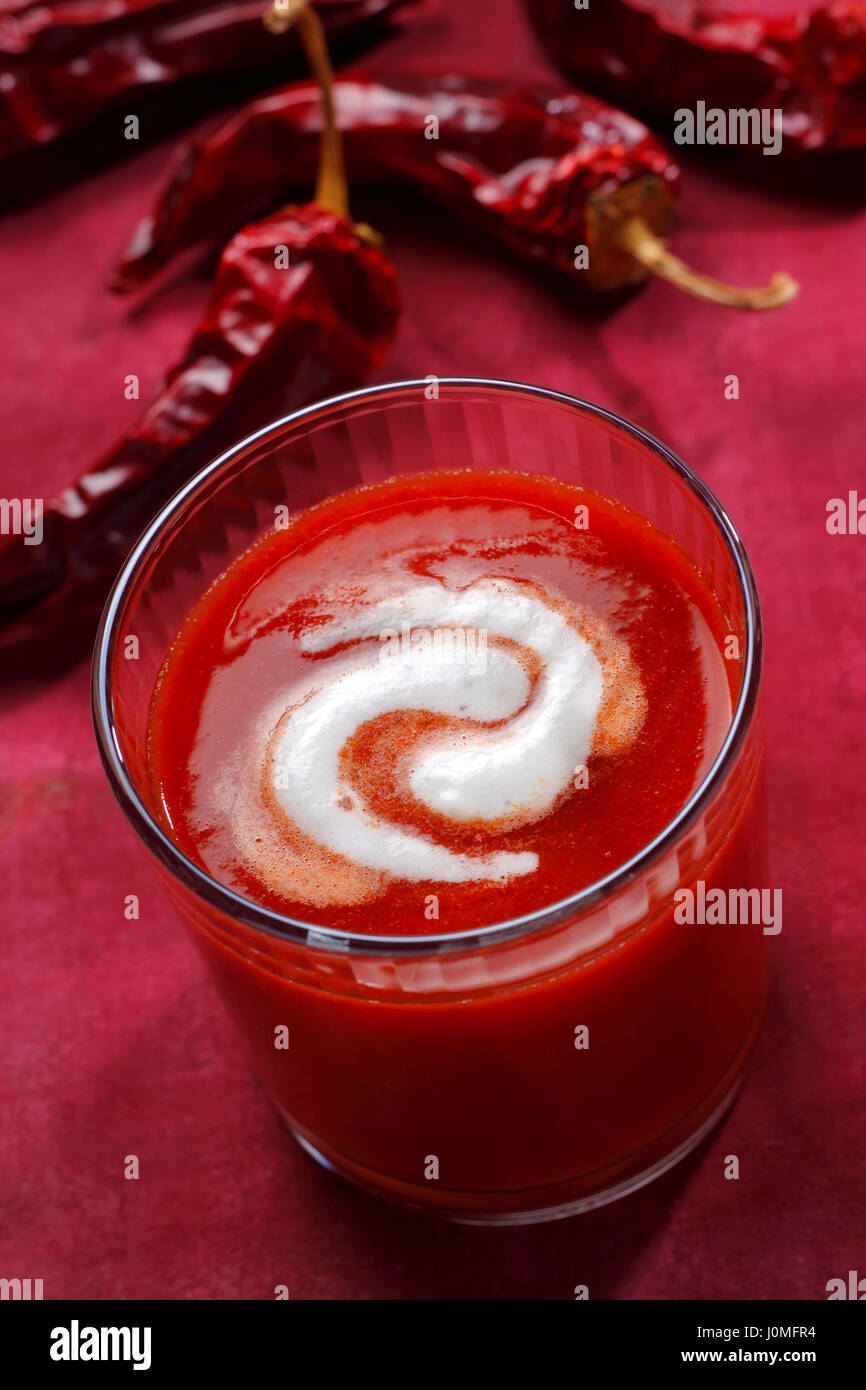 Tomato soup in glass with whipped cream swirl Stock Photo