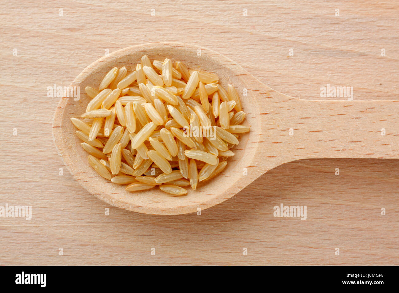 Wooden spoon filled with brown rice grains. Close-up, top view Stock ...