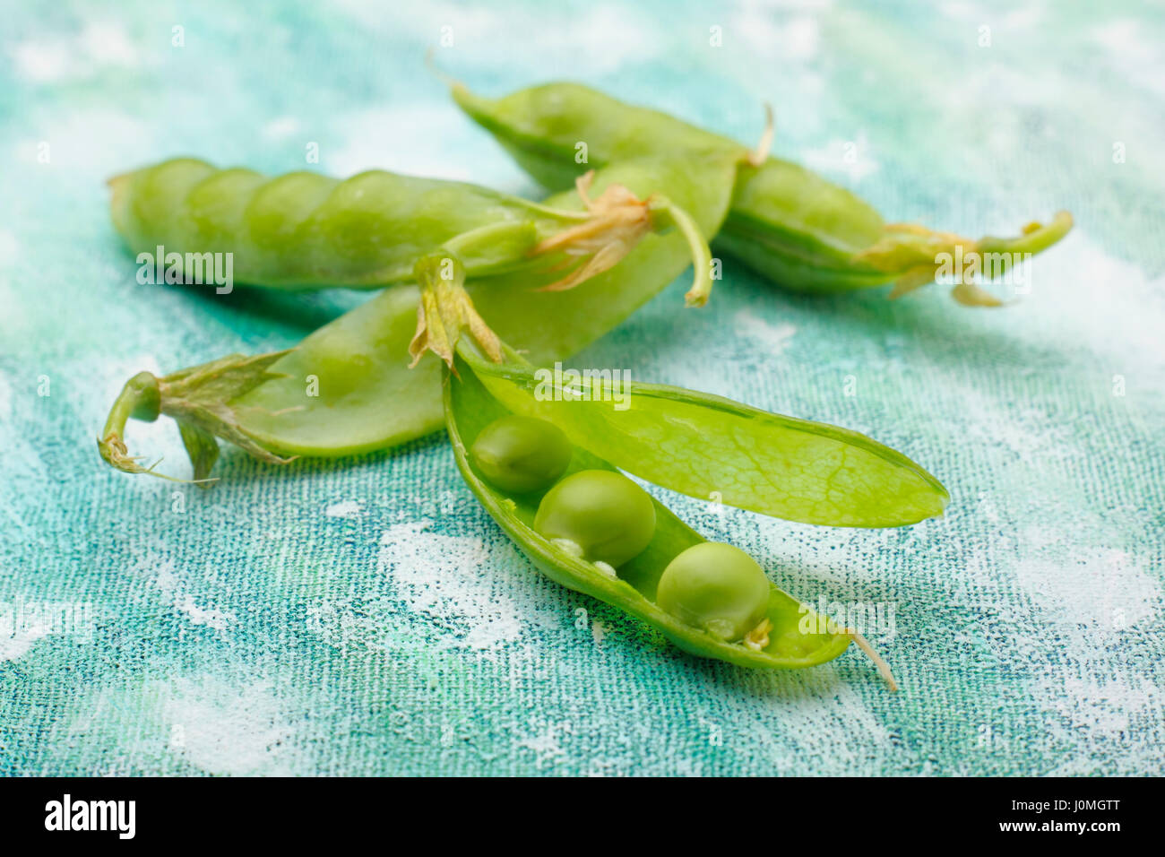 Fresh green pea pods with one pod opened. Stock Photo