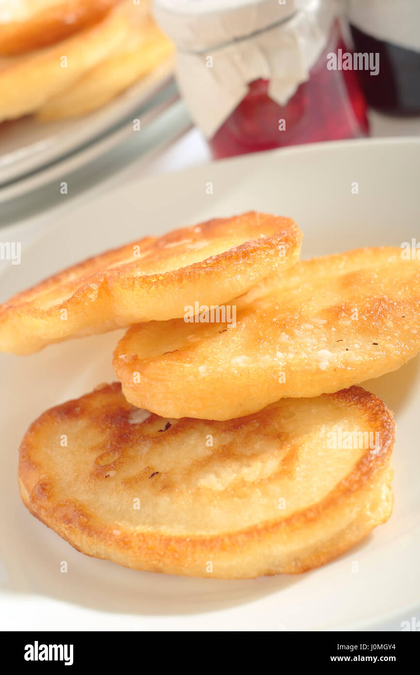 Close-up view of three Polish doughnuts (racuchy) on plate with  blurred background. Oblique view. Stock Photo