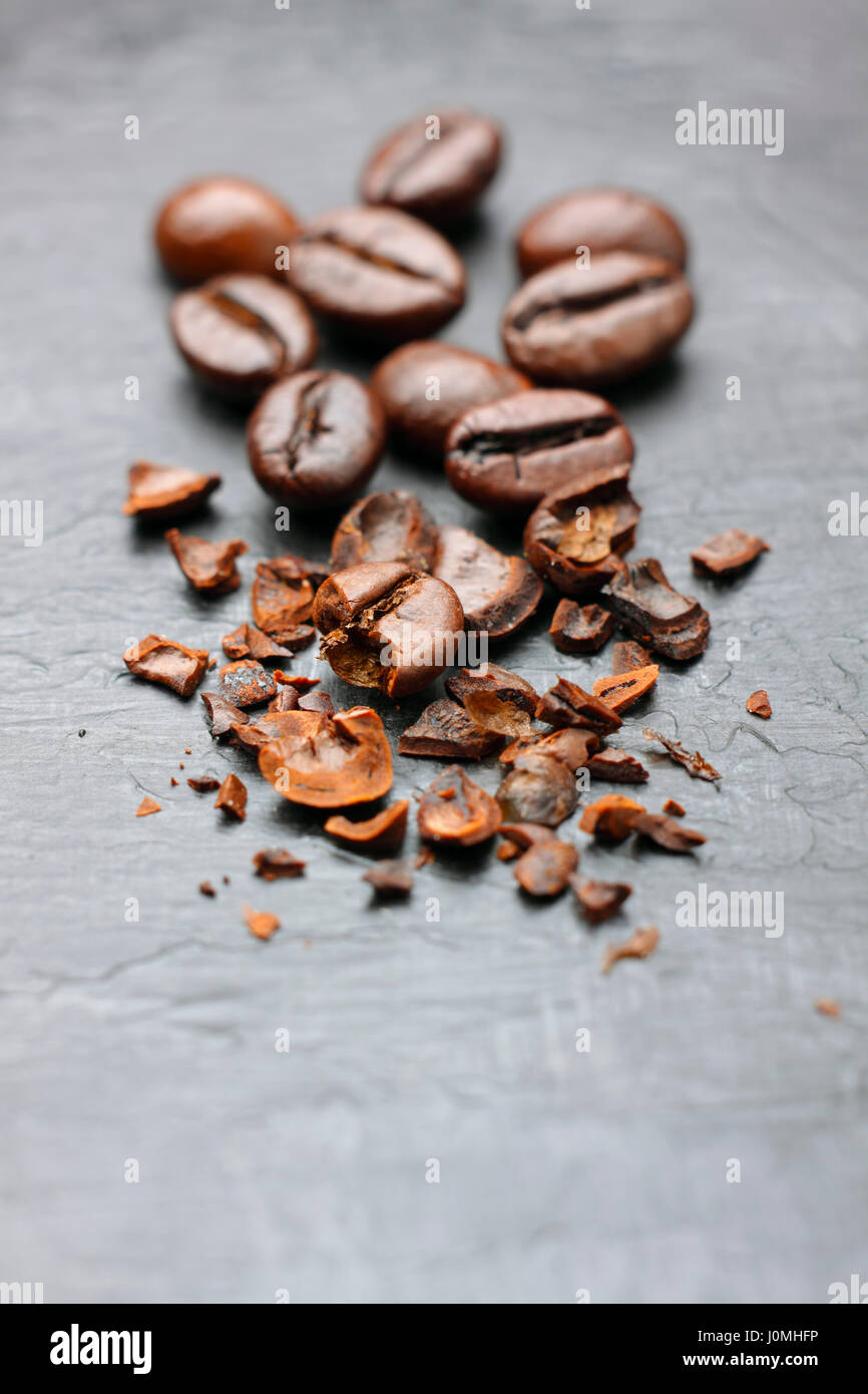 Coffee (Robusta coffee) beans close-up. Some beans crumbled. Stock Photo