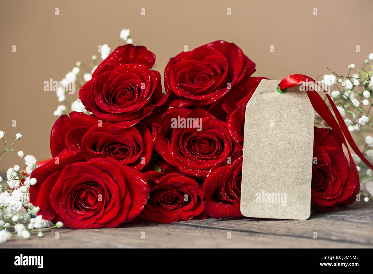 Red rose and blank gift card for text background Stock Photo - Alamy