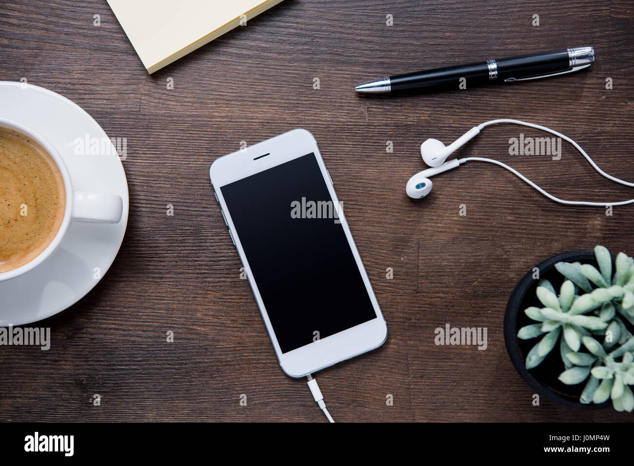 Top view of coffee cup, smartphone with blank screen and earphones ...