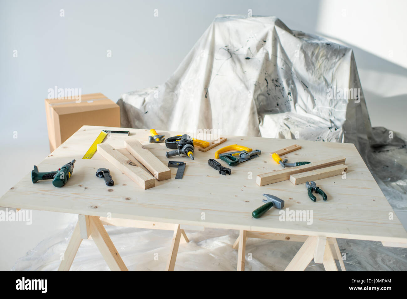 Toy tools and wooden planks on table in workshop Stock Photo