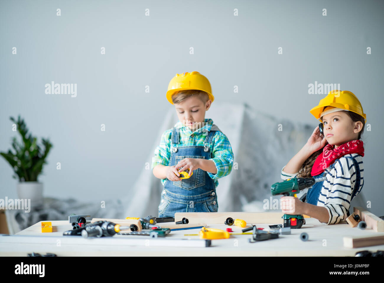 Cute Little Boy And Girl In Hard Hats Playing With Toy Tools Stock Photo Alamy