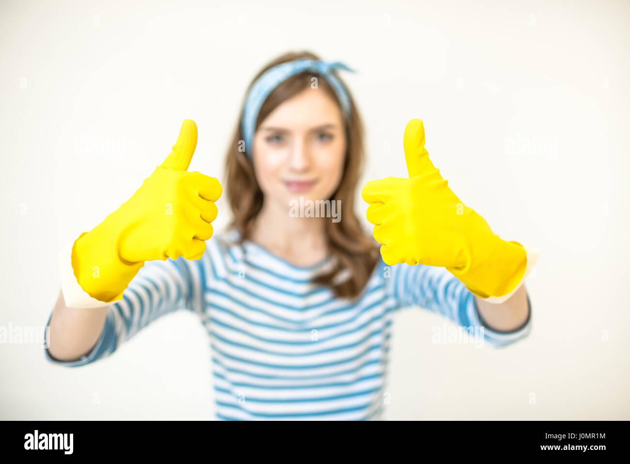 Young smiling woman in rubber gloves showing thumbs up Stock Photo - Alamy