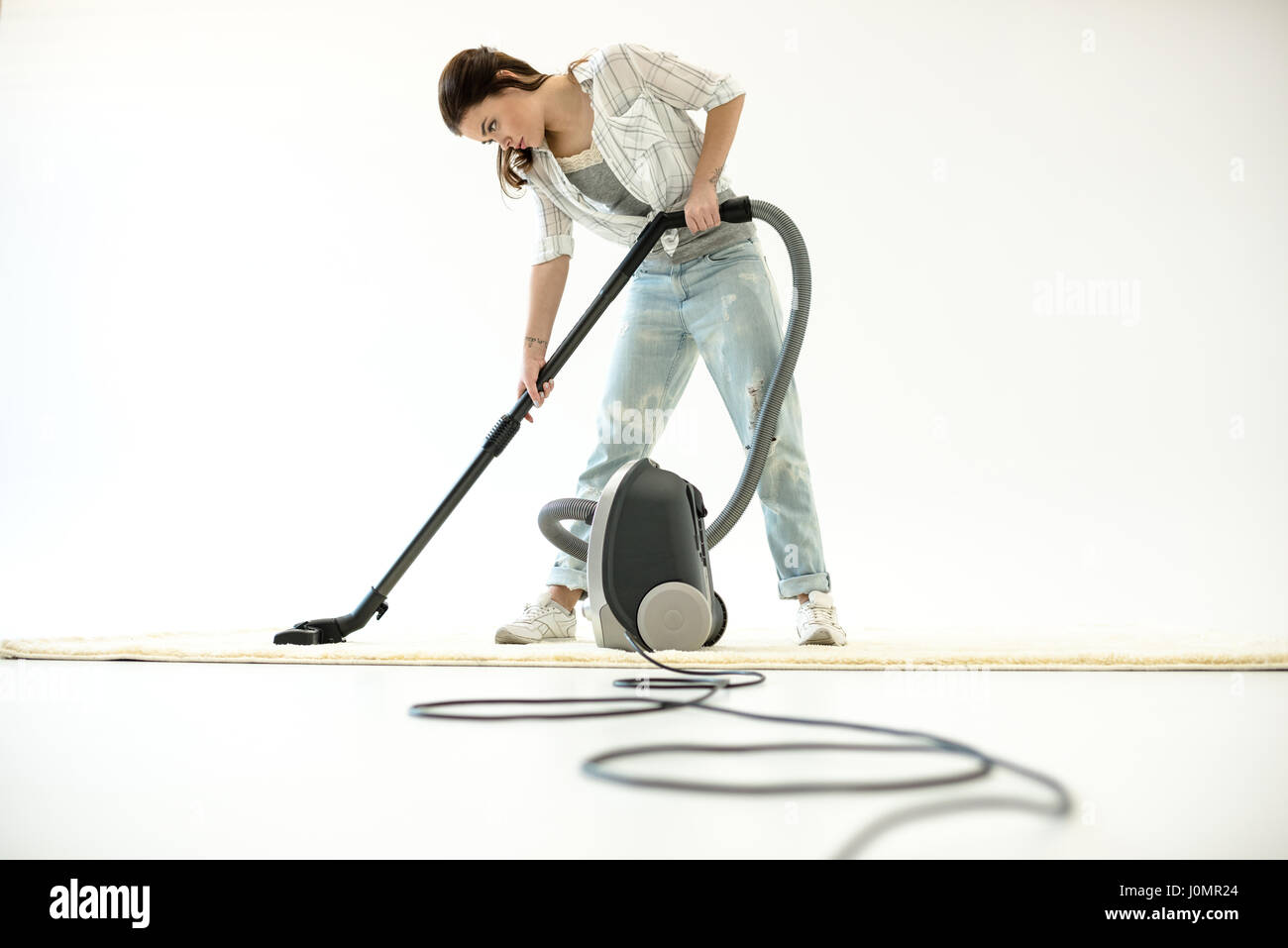Young attractive woman cleaning carpet with vacuum cleaner Stock Photo ...