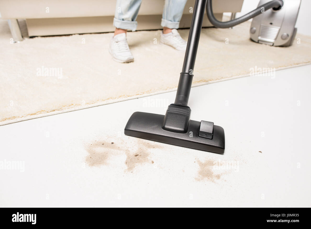 Low section view of woman removing floor stains with vacuum cleaner
