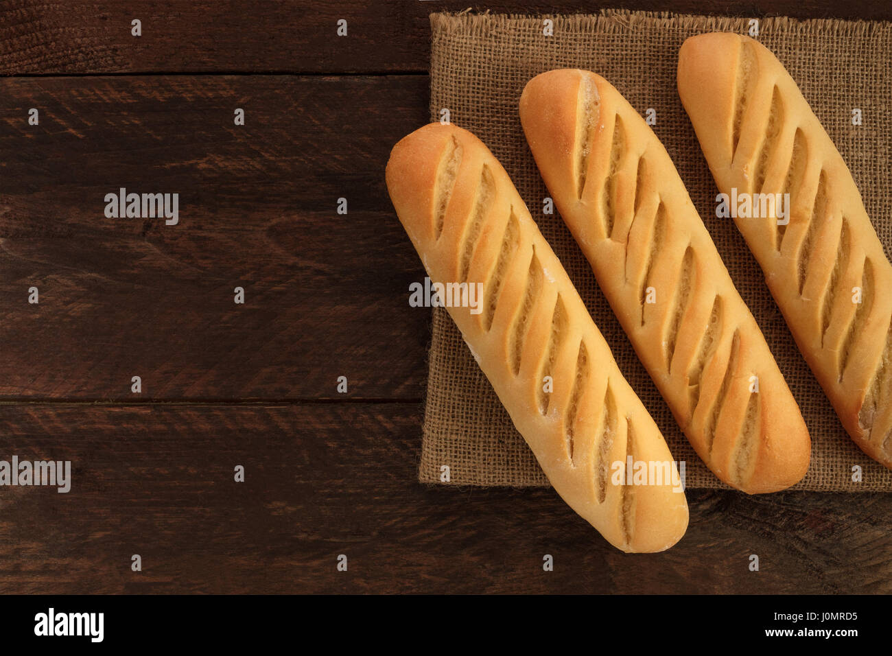 An overhead photo of freshly baked loaves of white bread on a rustic ...