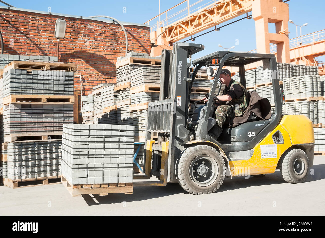 Driver on lift truck loads products of plant Stock Photo Alamy
