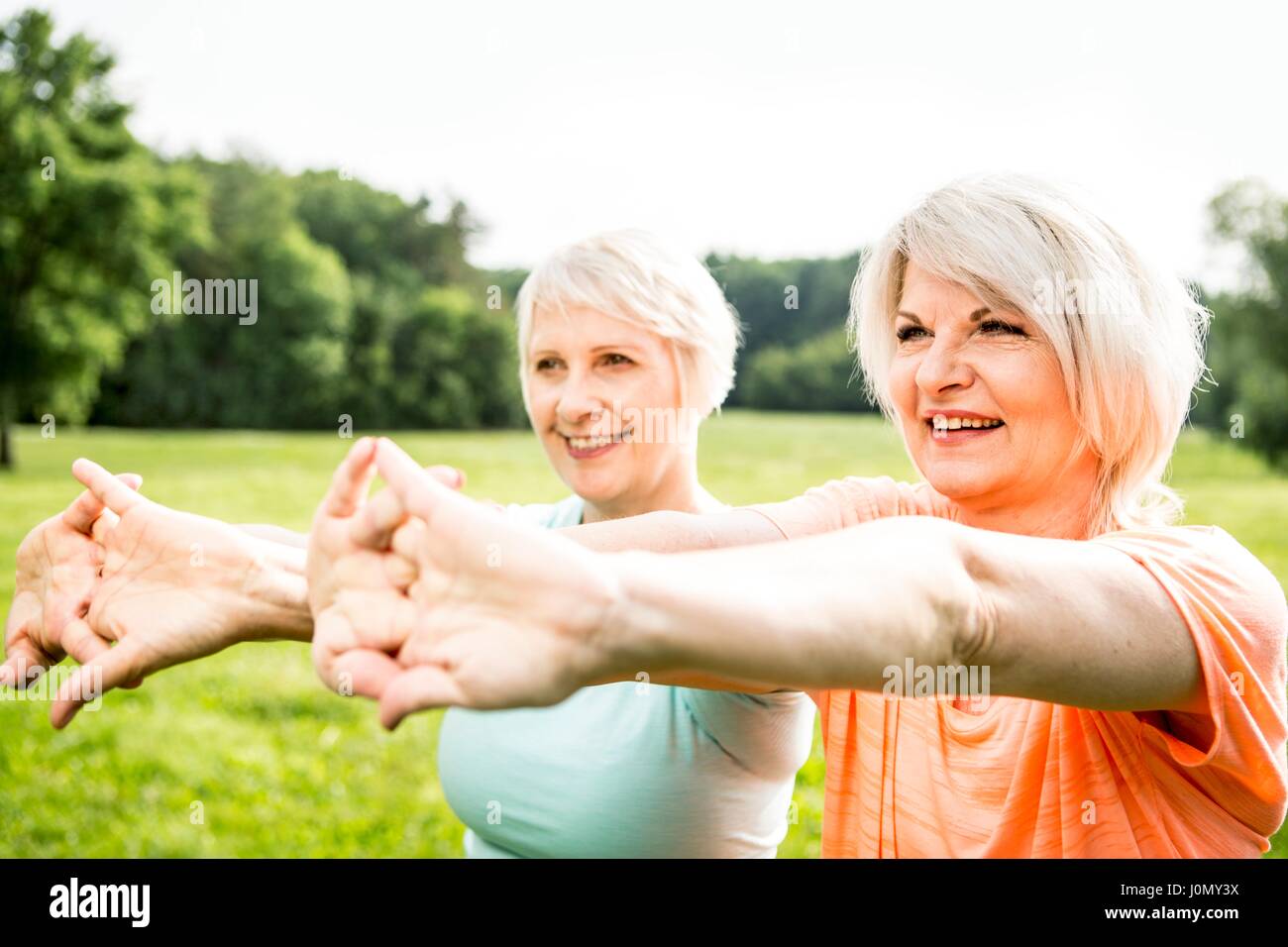 Two women exercising with arms outstretched. Stock Photo