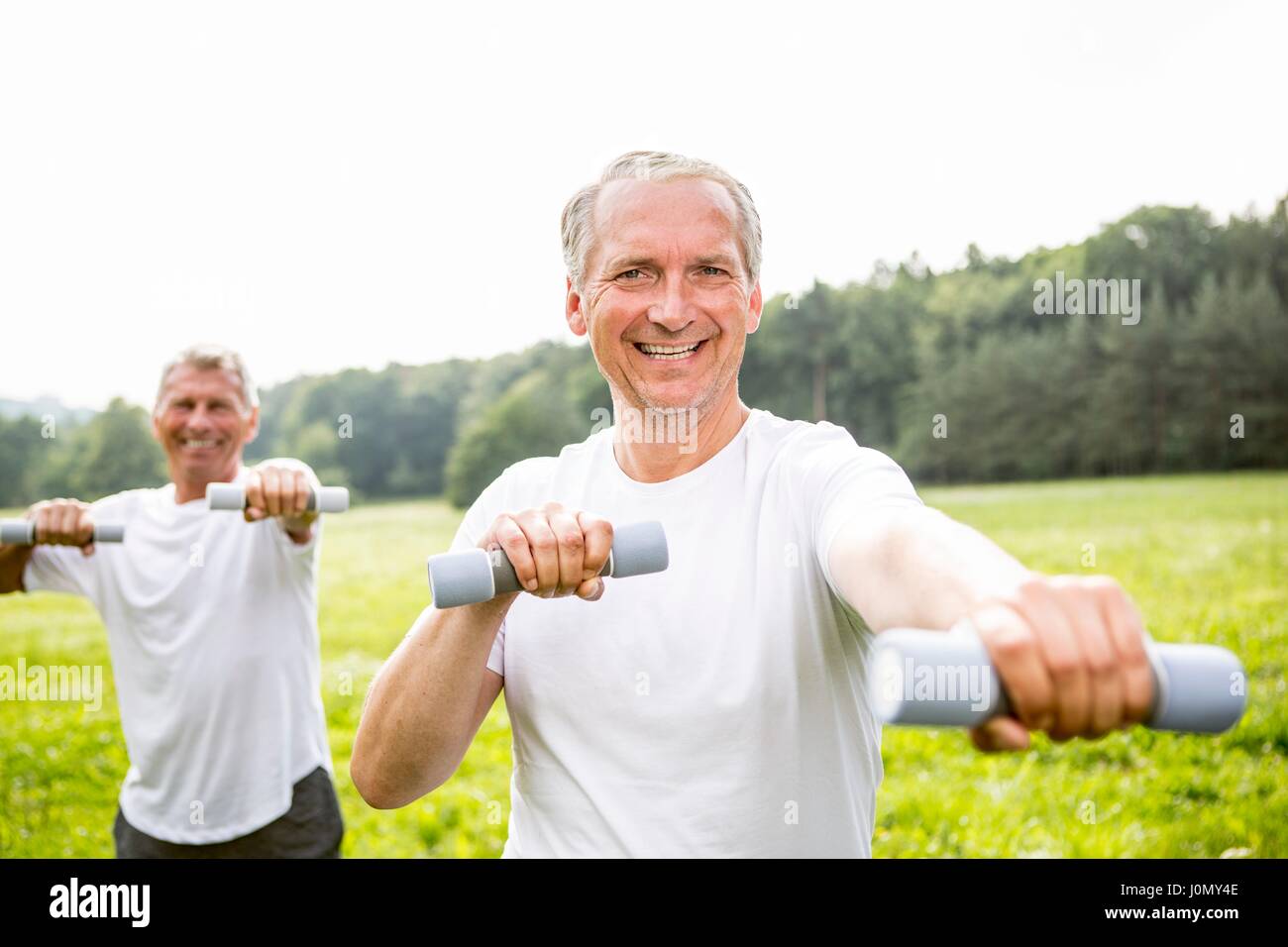 Two men exercising with hand weights. Stock Photo