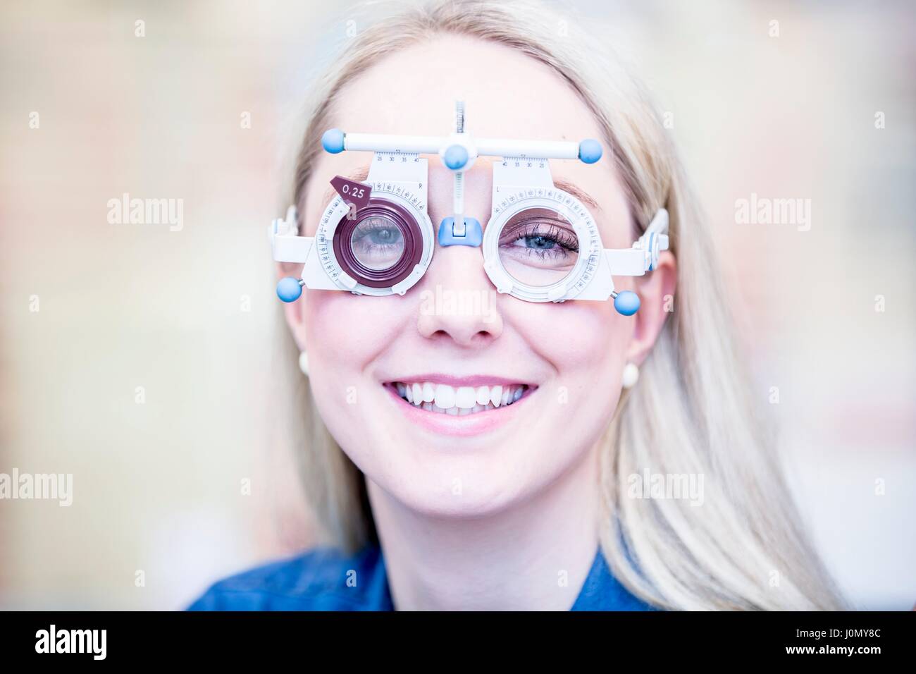 Portrait of cheerful young woman wearing trial frame, close-up. Stock Photo