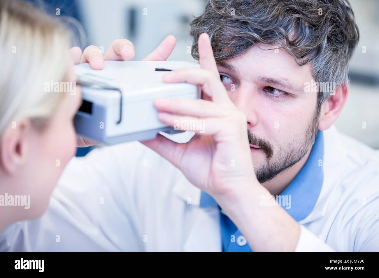 Optometrist performing eye test of young woman Stock Photo - Alamy