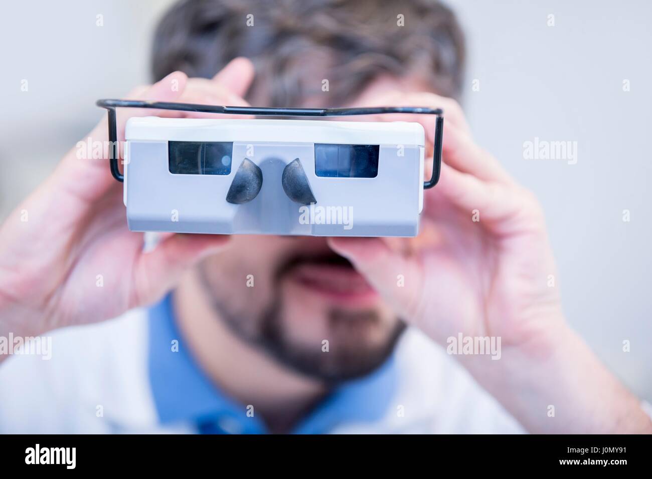 Portrait of Optometrist performing eye test with vision screener in optometrist's shop. Stock Photo