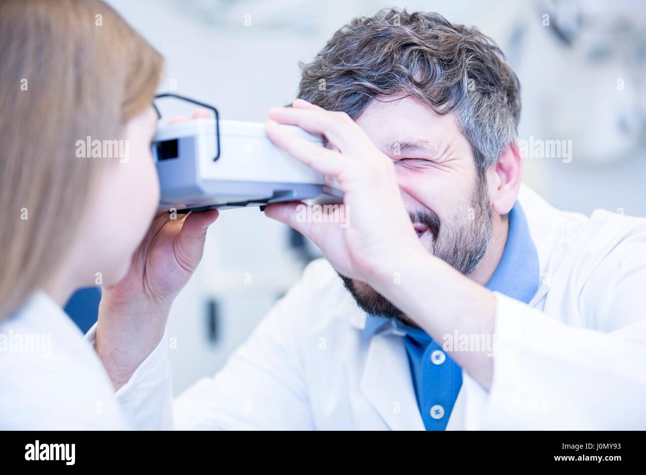 Optometrist performing eye test of young girl Stock Photo - Alamy