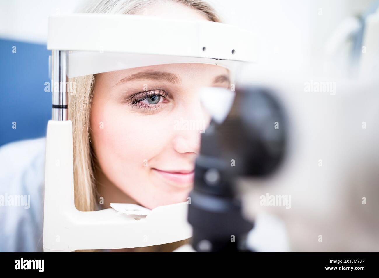 Eye examination of young woman with slit lamp. Stock Photo