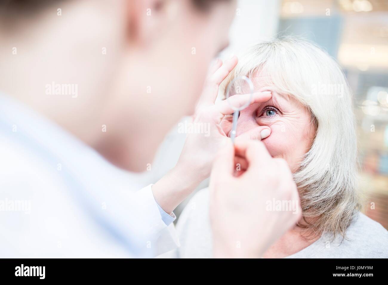 Optometrist holding magnifying glass. Stock Photo