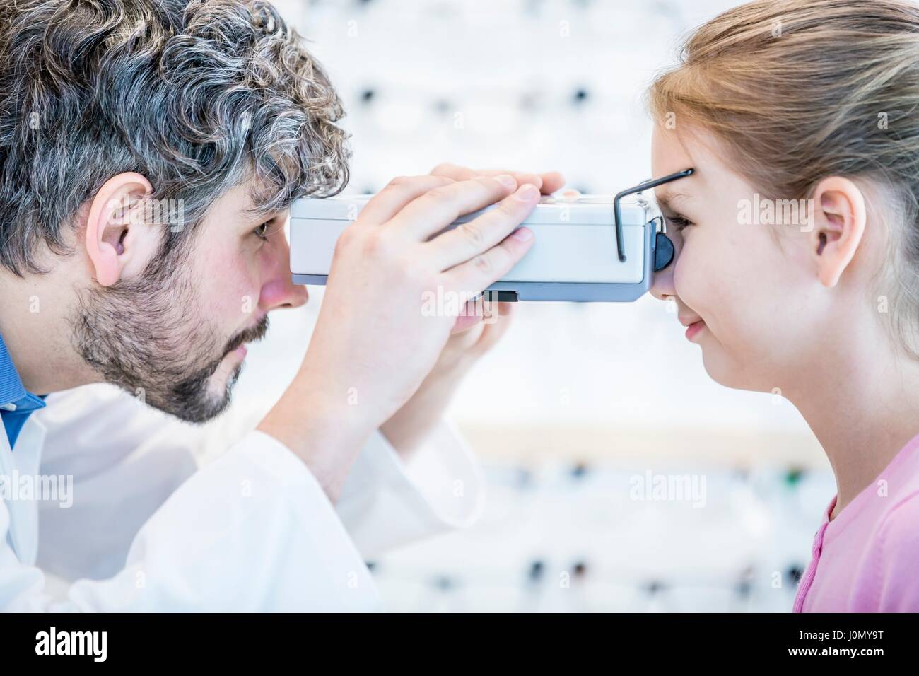 Optometrist performing eye test of young girl Stock Photo - Alamy