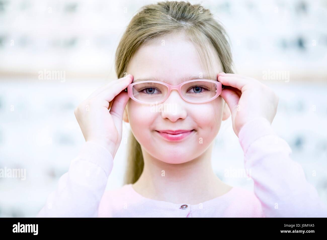 Portrait of girl trying glasses in optometrist's shop. Stock Photo
