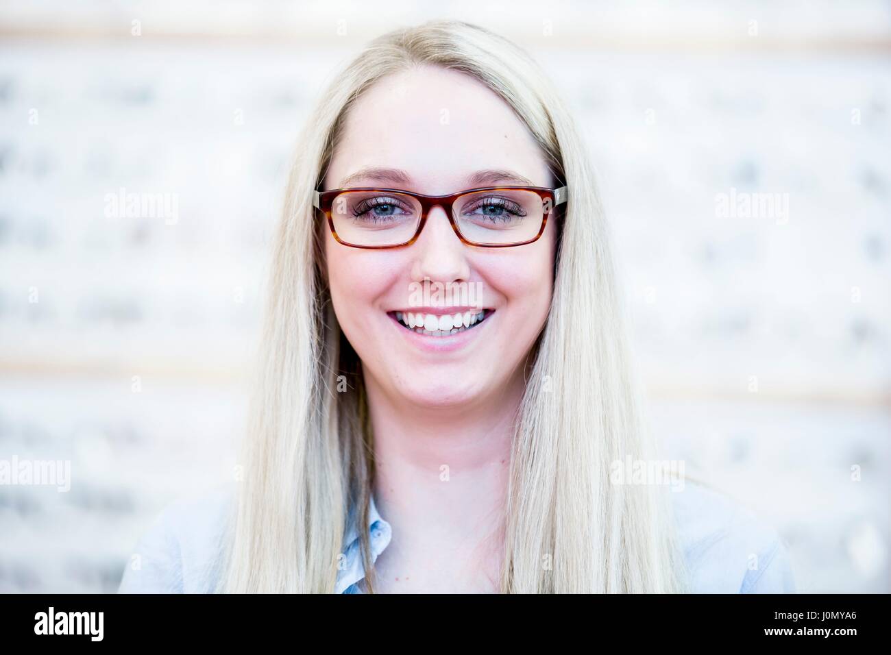 Portrait of woman trying glasses in optometrist's shop. Stock Photo