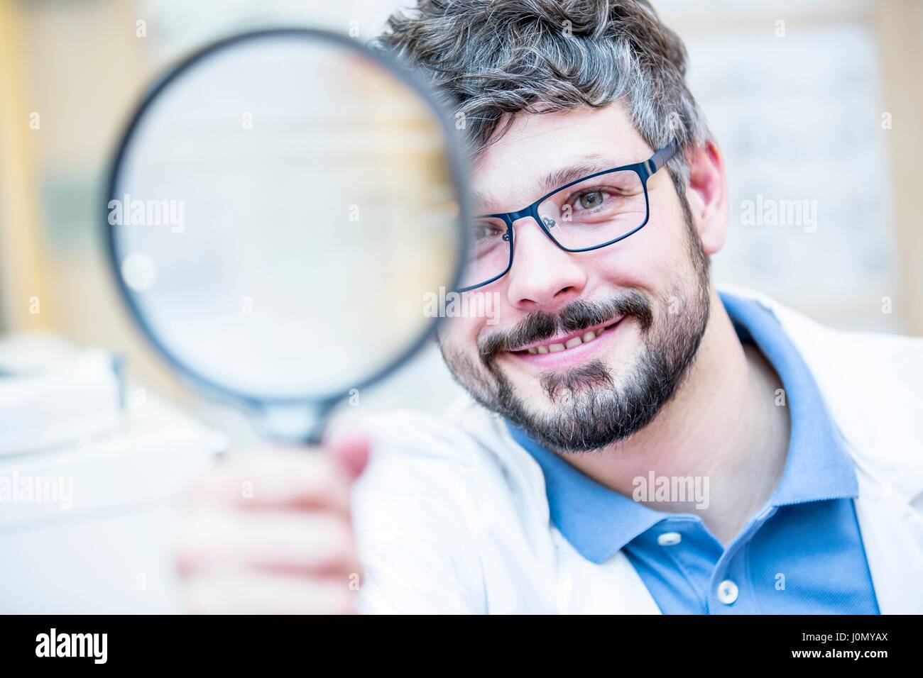 Close-up of optometrist holding magnifying glass. Stock Photo