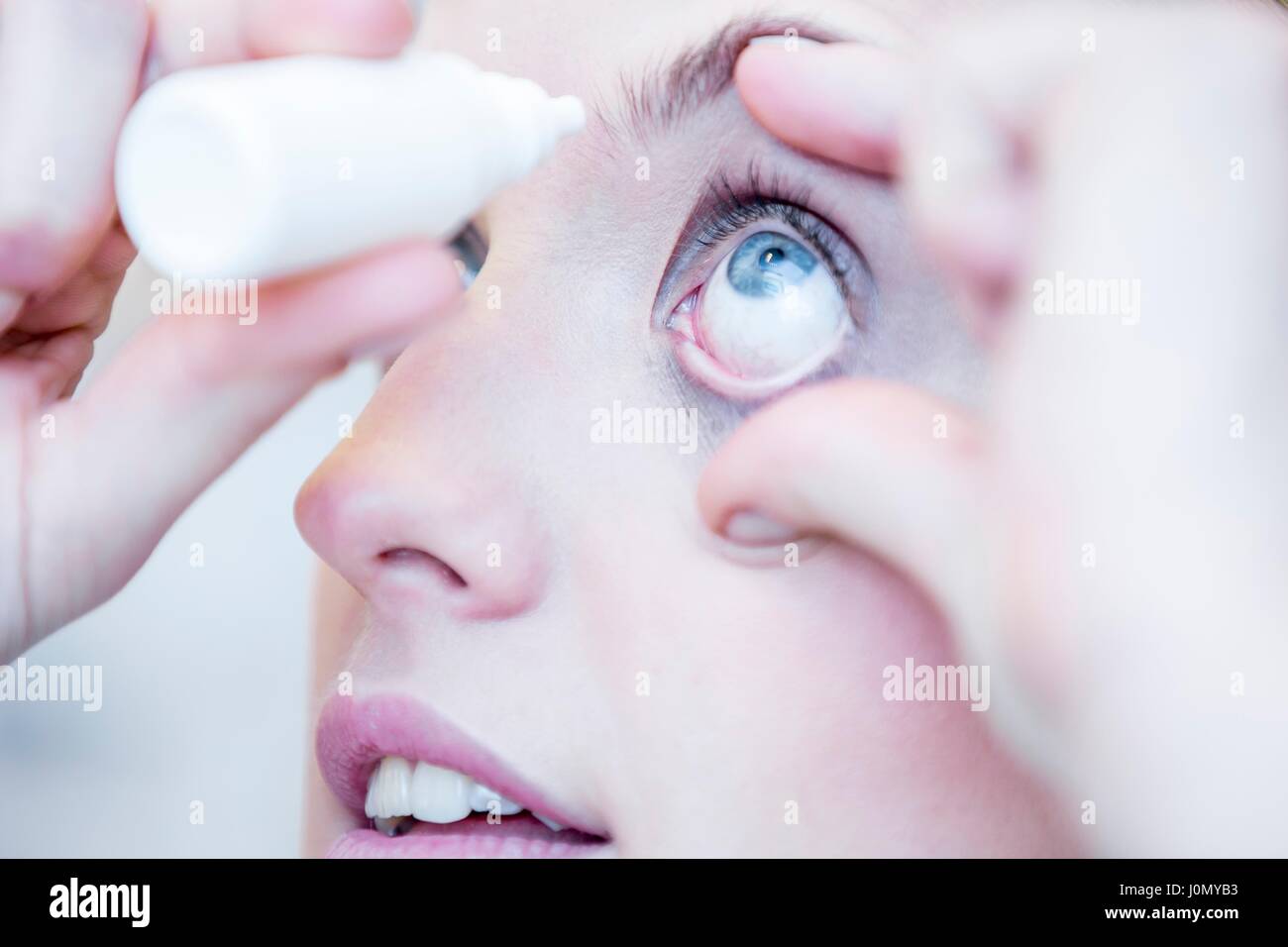 Close-up of person applying eye drops. Stock Photo