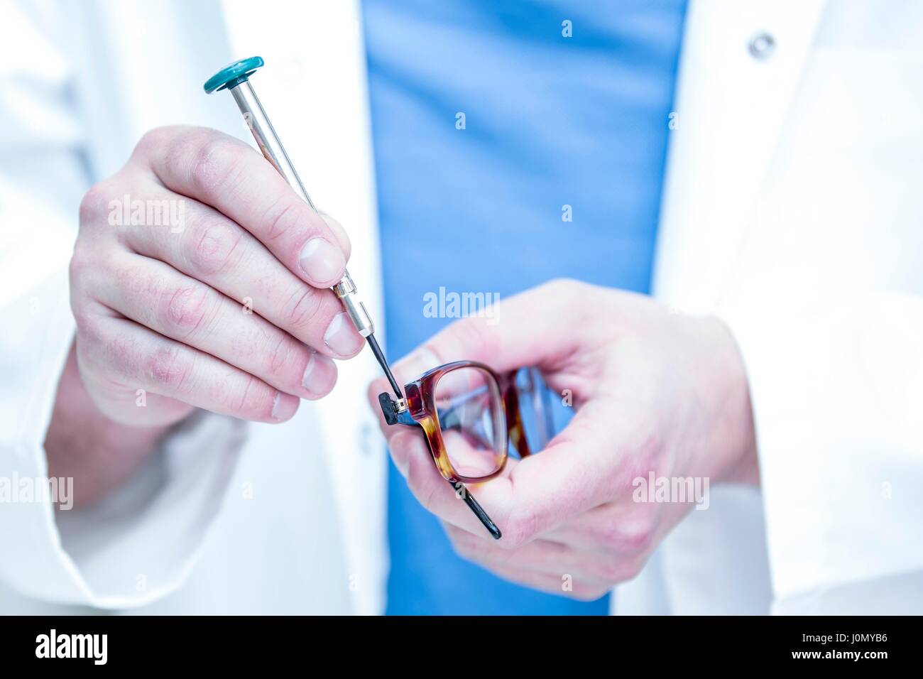 Close-up of optician repairing eyeglasses. Stock Photo