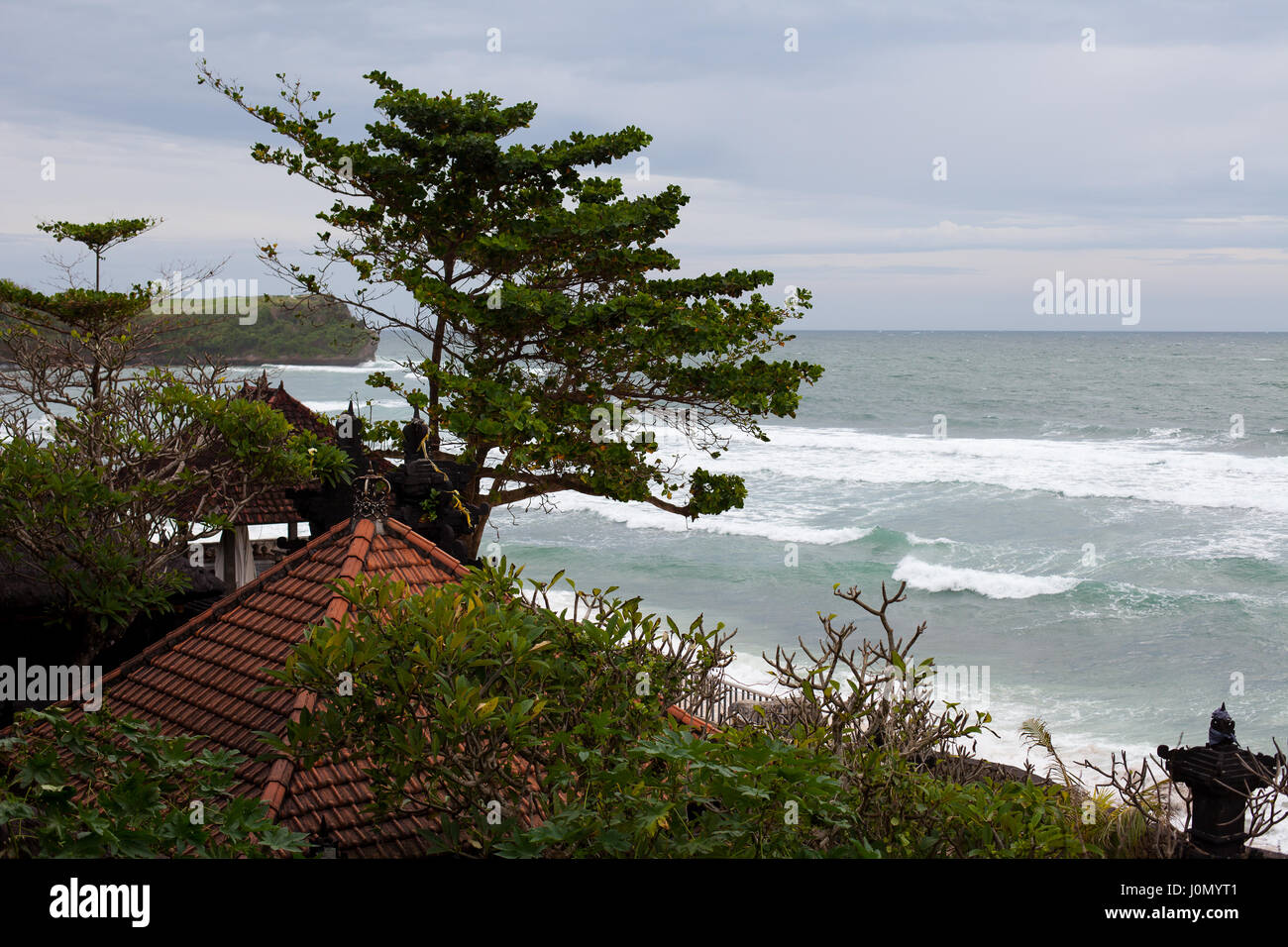 The wind shakes the trees and catches a wave in the ocean temple on the sea shore Stock Photo