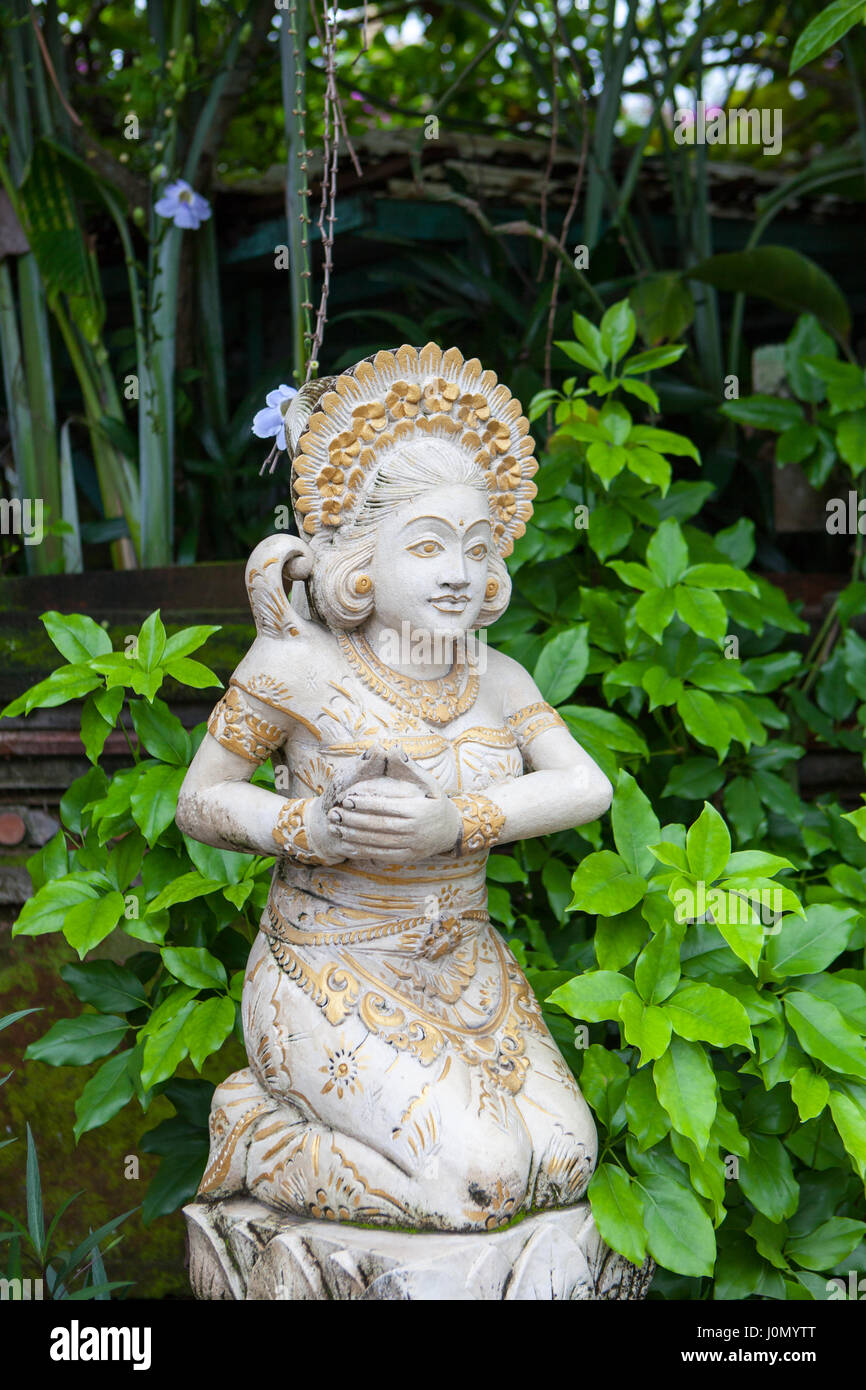 Girl statue in white stone in Balinese style on the background of greenery, Indonesia Stock Photo