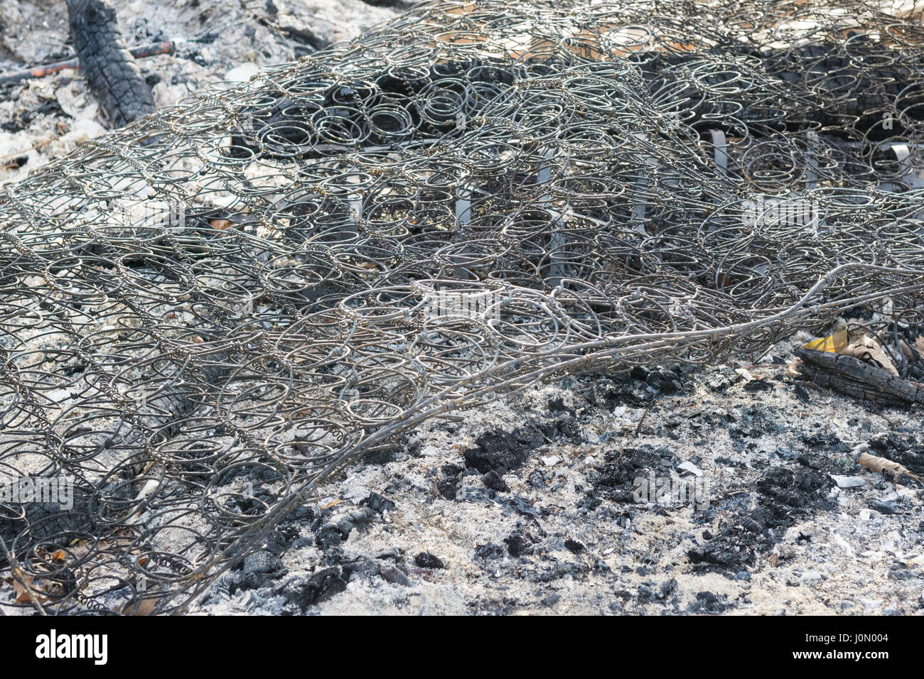 Burnt mattress mattresses springs on bonfire Stock Photo