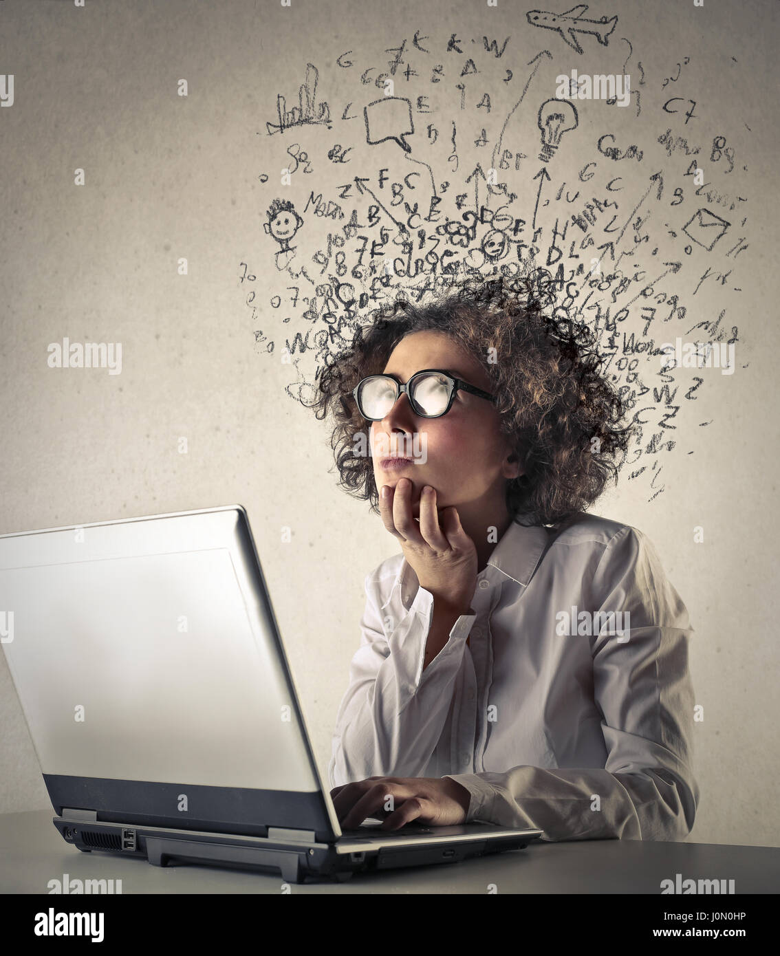 Woman thinking in front of laptop Stock Photo