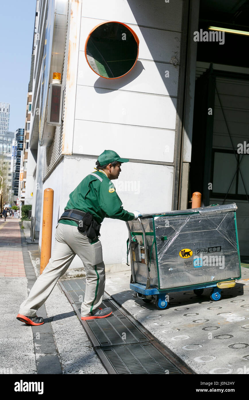 Tokyo, Japan. 14th April, 2017. A Yamato Transport worker pushes a