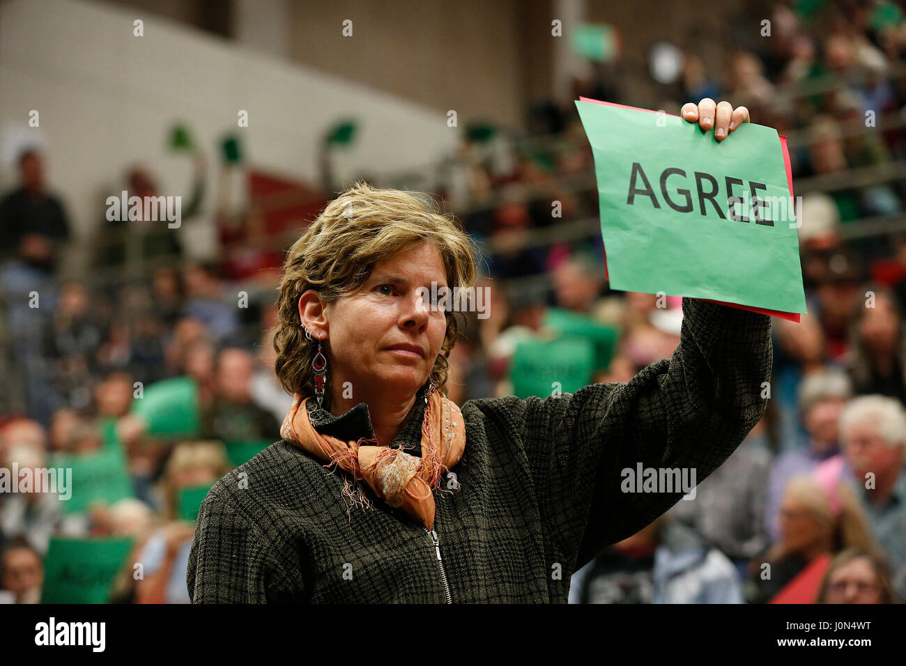 A woman signals her support of criticism of U.S. Rep. Greg Walden (R-OR) during a constituent town hall meeting on April 13, 2017. Bend, Oregon, United States. Stock Photo