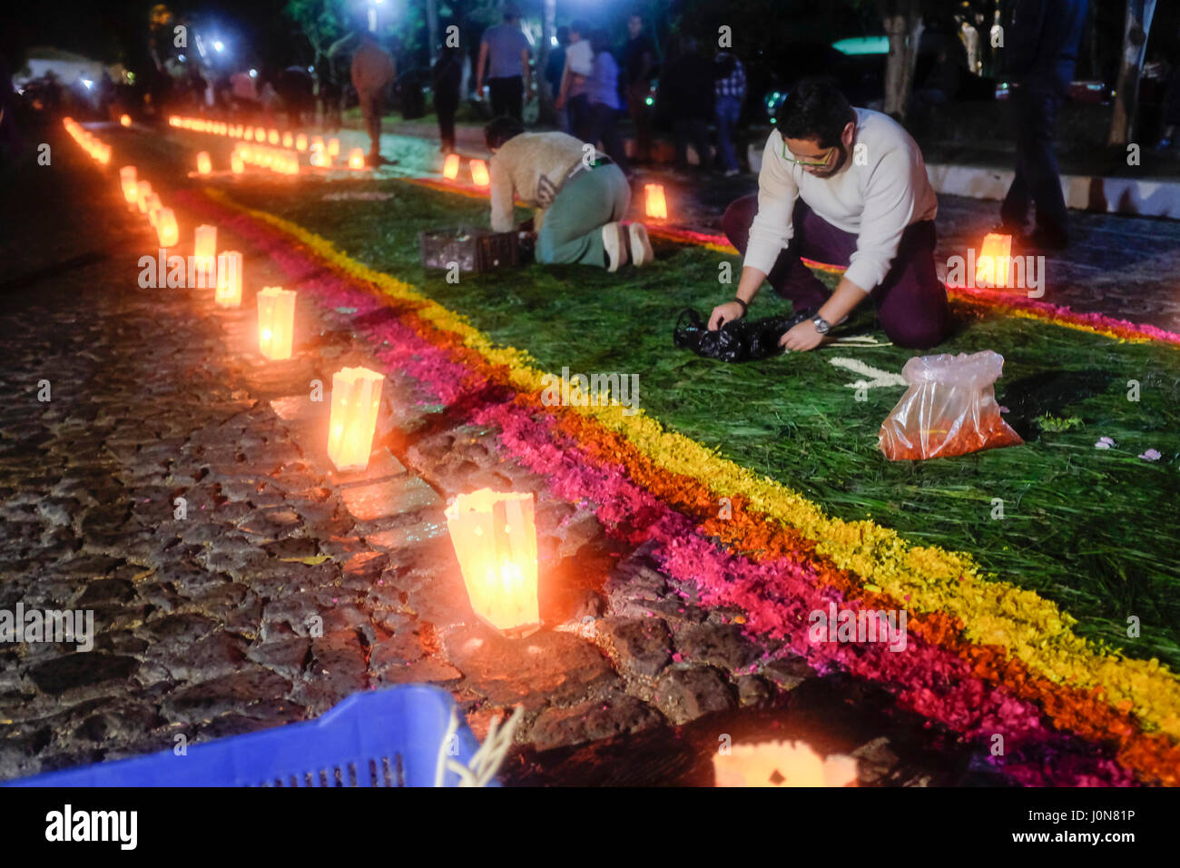 Parishioners from the Escuela de Cristo church spread flower pedals to create an 'alfombra', or carpet, as part of the annual Holy Week processions in Antigua, Guatemala on April 14, 2017. Stock Photo