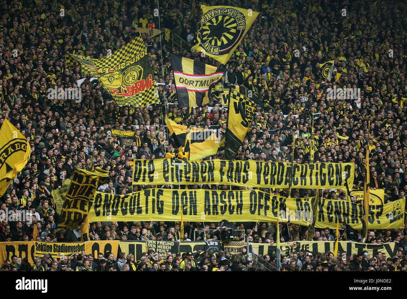 Fans of Dortmund hold up banners reading: 'Die eigenen Fans verdächtigen? Endgültig den Arsch offen, Roeckenhaus?' (lit. 'Suspecting your own fans? Have you gone insane, Roeckenhaus?') during the German Bundesliga soccer match between Borussia Dortmund and Eintracht Frankfurt at the Signal Iduna Park in Dortmund, Germany, 15 April 2017. (EMBARGO CONDITIONS - ATTENTION: Due to the accreditation guidelines, the DFL only permits the publication and utilisation of up to 15 pictures per match on the internet and in online media during the match.) Photo: Ina Fassbender/dpa Stock Photo