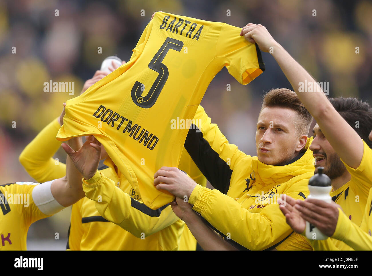 dpatop - Dortmund's Marco Reus, Nuri Sahin (R) and other players hold up the jersey of Marc Bartra after the 3-1 win after the German Bundesliga soccer match between Borussia Dortmund and Eintracht Frankfurt at the Signal Iduna Park in Dortmund, Germany, 15 April 2017. Marc Bartra was heavily injured after the bomb attack on Dortmund's team bus on the 11 April 2017. (EMBARGO CONDITIONS - ATTENTION: Due to the accreditation guidelines, the DFL only permits the publication and utilisation of up to 15 pictures per match on the internet and in online media during the match.) Photo: Ina Fassben Stock Photo