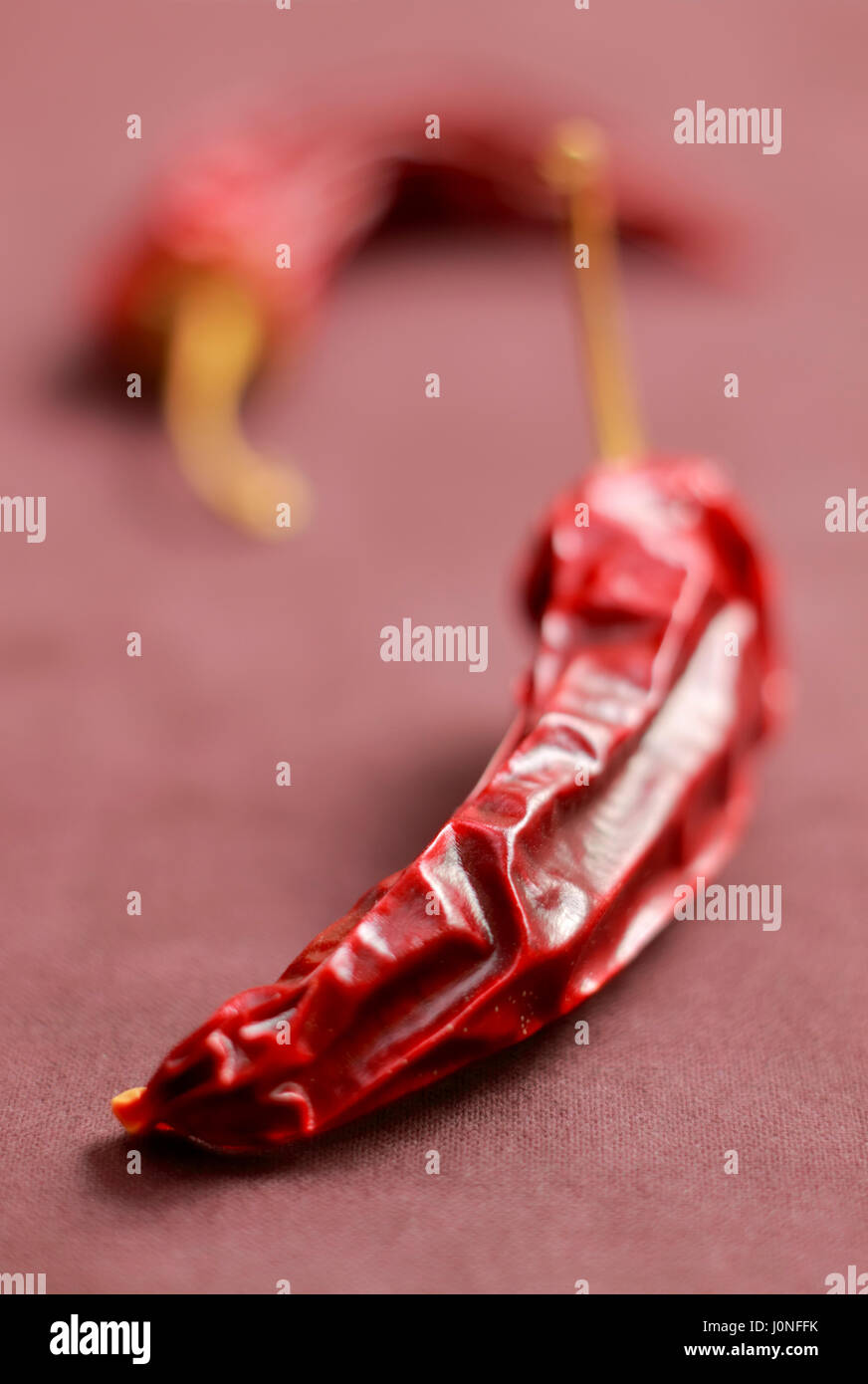 Close-up of dried chilli peppers on textile background Stock Photo