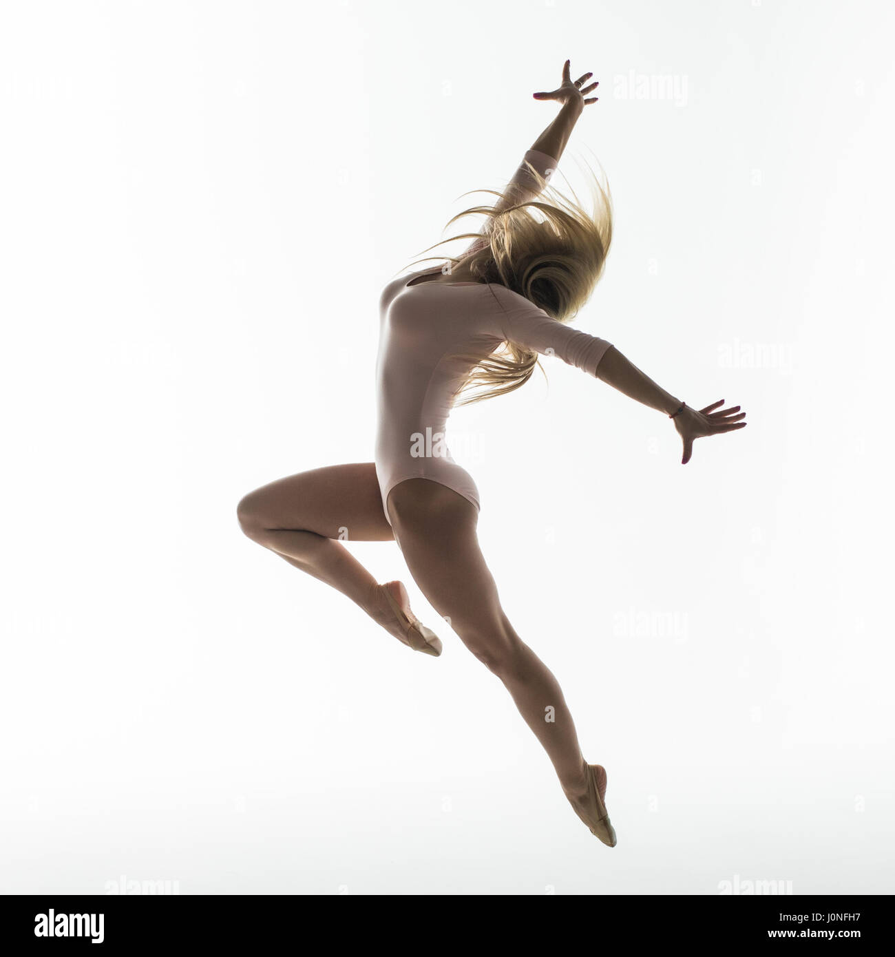 Young slim gymnast in studio on white Stock Photo