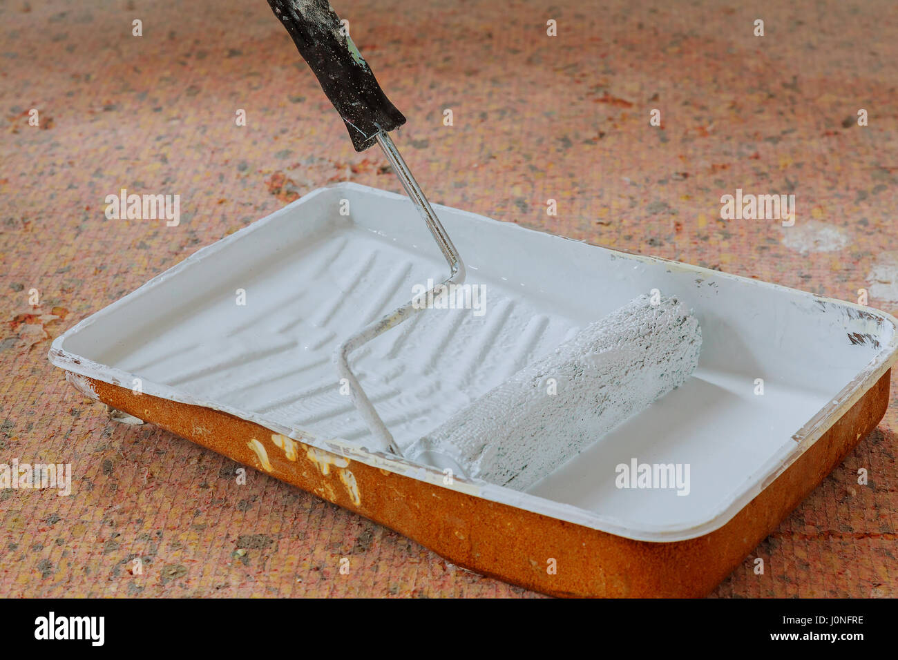 Realistic image of paint pan and roller on drop cloth during painting