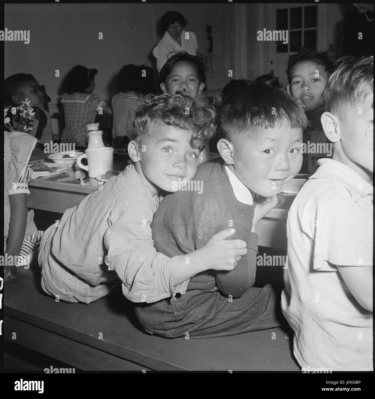 Children socialize during lunch at the Raphael Weill Public School in San Francisco, California, before people of Japanese descent were evacuated for War Relocation Authority centers, 1942. Stock Photo
