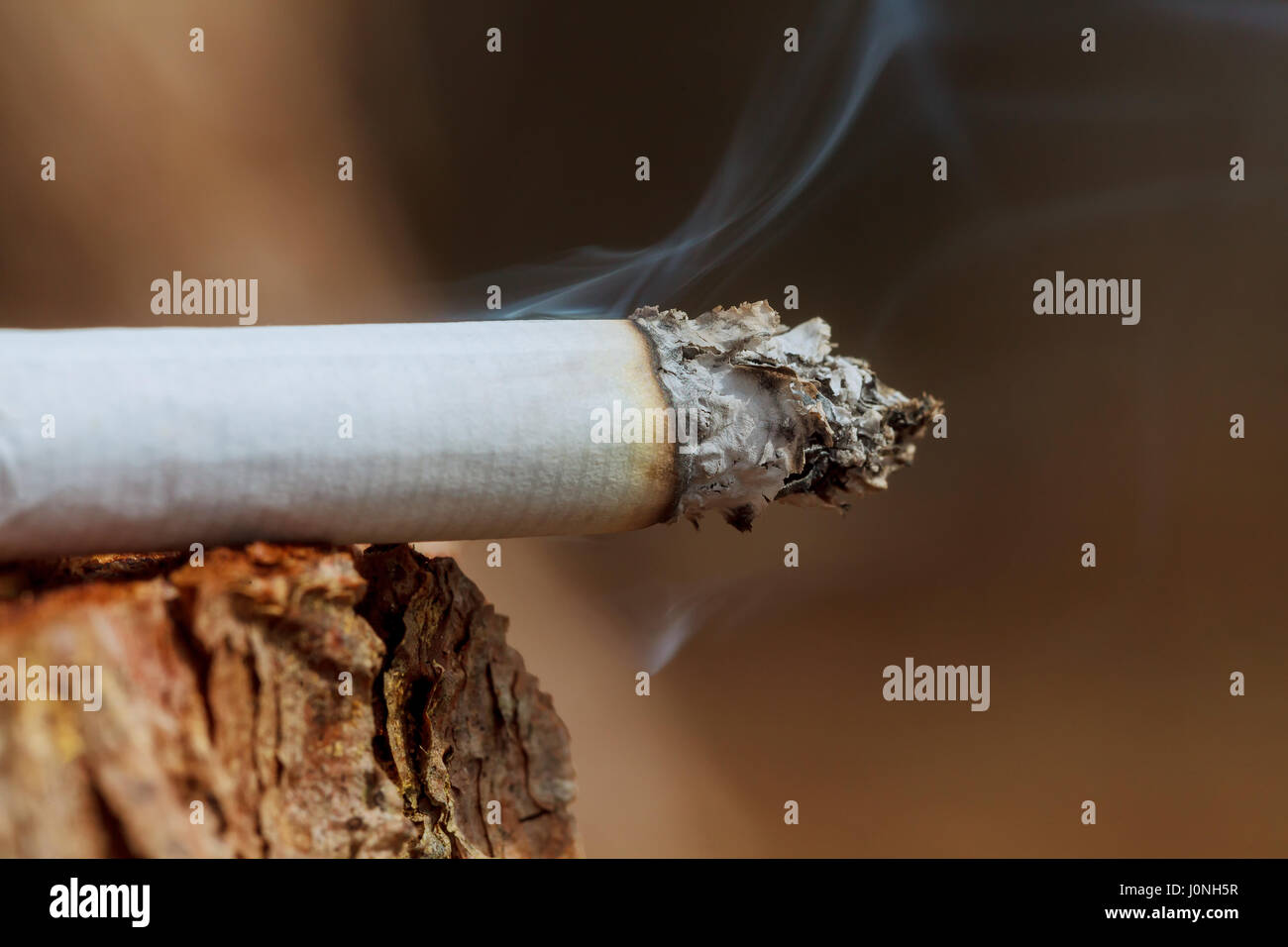 Cigarette with smoke on wooden background Cigarette smoking Stock Photo
