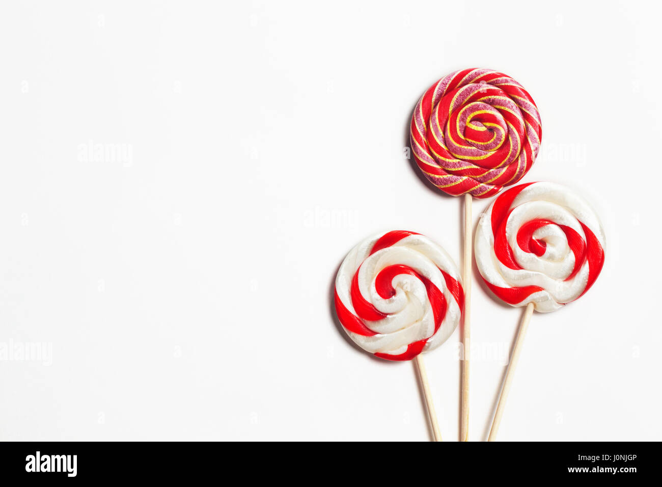 Lollipops on a stick on a white background. Flat lay. Shallow DOF. Copy space Stock Photo