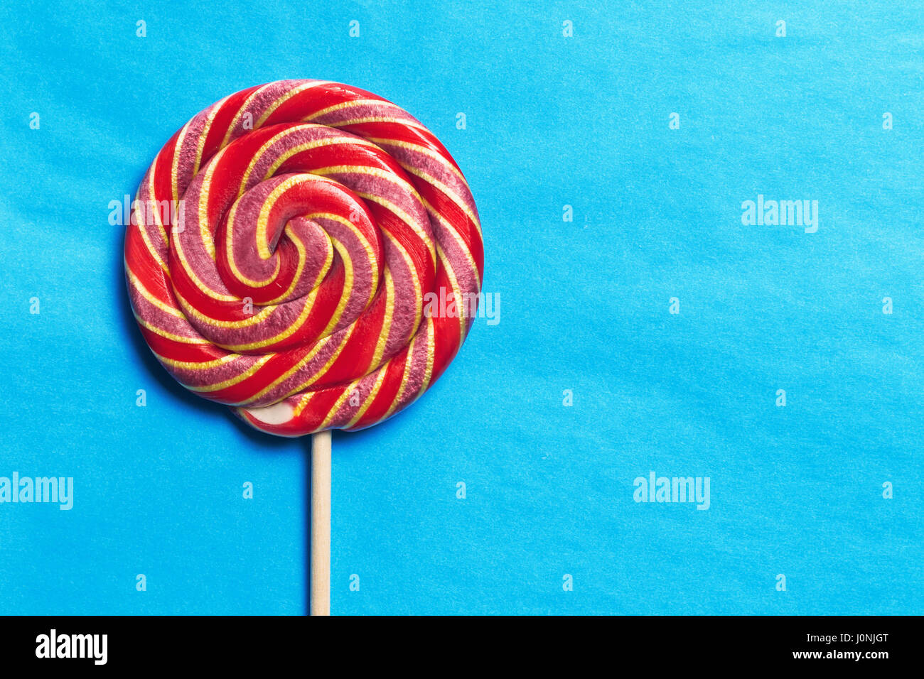 Lollipops on a stick on a blue background. Flat lay. Shallow DOF. Copy space Stock Photo