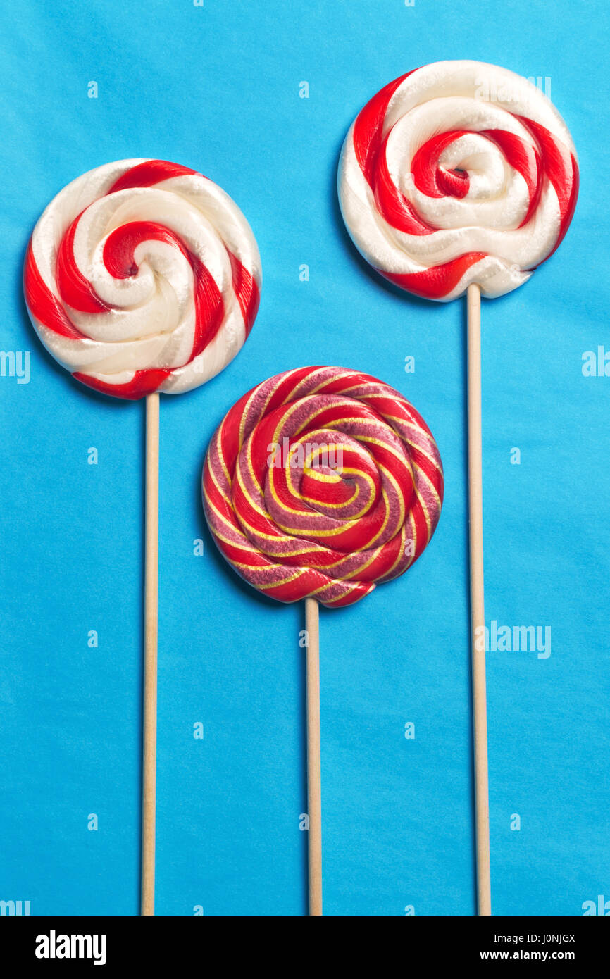 Lollipops on a stick on a blue background. Flat lay. Shallow DOF. Stock Photo
