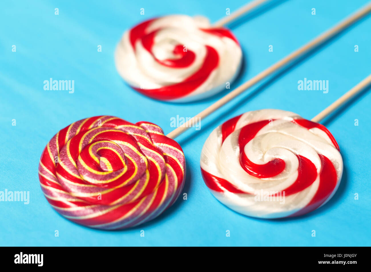 Lollipops on a stick on a blue background. Flat lay. Shallow DOF. Stock Photo