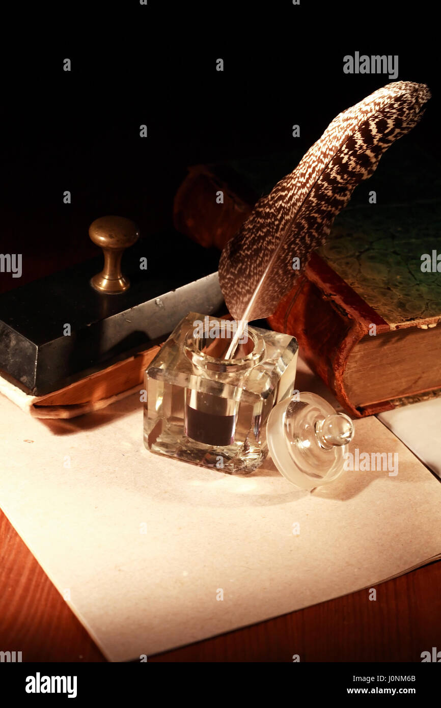 Literature concept. Stylish vintage inkwell near old book on dark