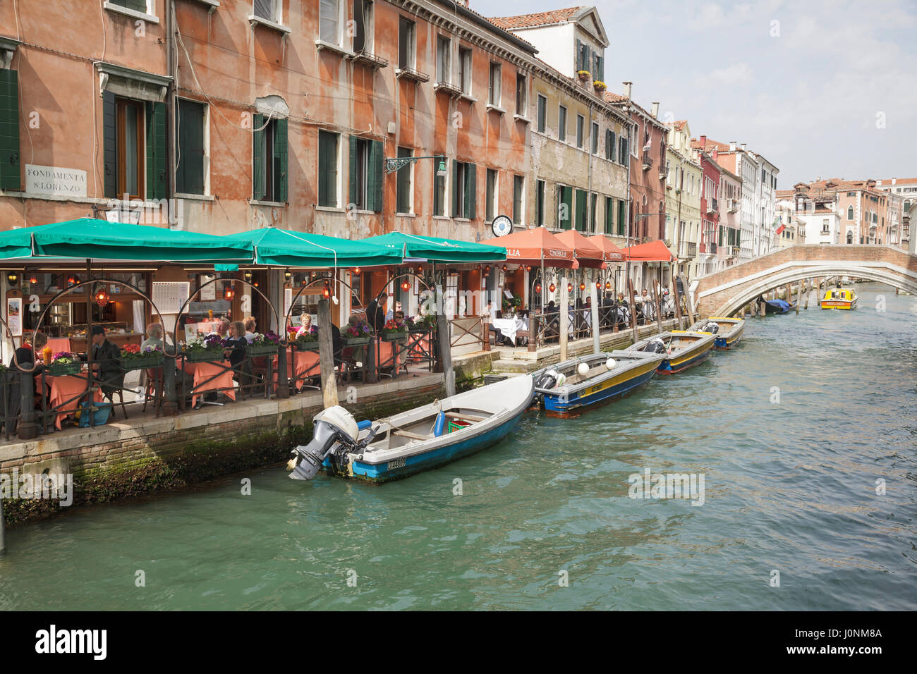 canal with outdoor restaurant on Fondamenta San Lorenzo, Venice, Veneto, Italy Stock Photo